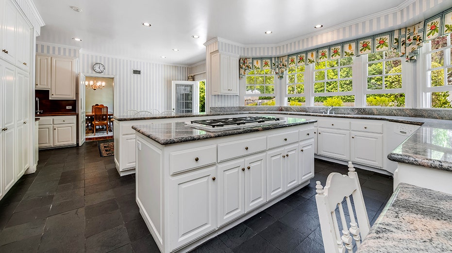 The kitchen features a center island and a wall of windows.